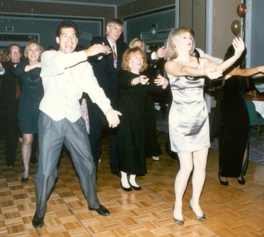 dance floor full of people in black tie attire doing the Macarena